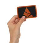 Embroidered Bank of Zaonce patch logo in orange held by hand