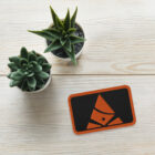Embroidered Bank of Zaonce logo in orange on table with 2 succulent plants