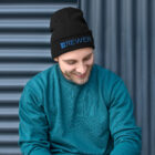 Man wearing black beanie with Brewer Corporation logo embroidered on the front in blue
